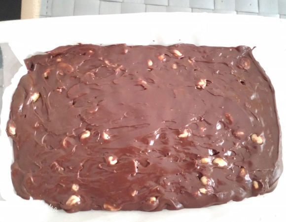 Выложить смесь в форму, разгладить. Я использую силиконовую лопатку.
Затем прикрыть сверху с двух сторон нашим запасом бумаги, которую мы оставили по бокам и разгладить ещё немного рукой. 