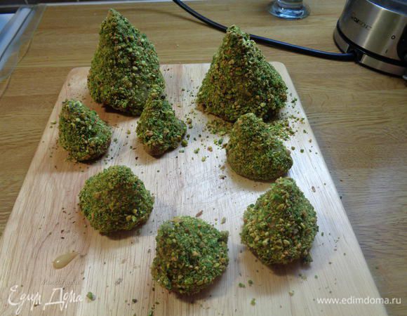 Обмазать каждое пирожное белым шоколадом, а затем обвалять в фисташках.