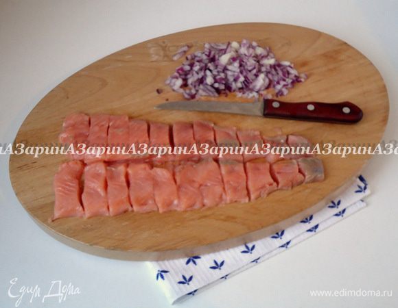 Приготовить начинку. Филе красной рыбы посолить, поперчить и разрезать на сегменты шириной по 2.5-3 см. Лук очистить и нарубить мелкими кубиками. 