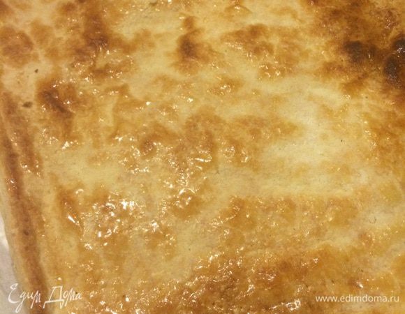 Духовку на 200С.

Итак, лист слоеного теста раскатываем и прокалываем по всей поверхности вилкоподобным прибором. Выкладываем на противень лист пергамента, затем раскатанный лист теста, сверху еще один лист пергамента и на него что-то плоское не тяжелое, по размеру близкое к параметрам коржа или больше (у меня это был небольшой алюминиевый противень). Этот приём позволяет получить ровный слоеный корж, идеальной толщины - не больше 1 см и без локальных вздутий (иначе это не мильфейный корж, а кривая булка-слойка). Выпекаем эту конструкцию около 20 мин. Вынимаем, даем немного остыть. Обильно присыпаем сахарной пудрой, прямо так, чтобы не было видно теста (именно поэтому лучше остудить корж, иначе пудра будет таять и вы переборщите с ней). Ставим корж уже без верхнего покрытия карамелизироваться в духовку еще на 5 мин (можно даже гриль добавить) до уверенного загара - это не перепеченность, это карамель на вашем хрустящем, блестящем и манящем корже. Из 4-х листов после выпекания и разрезания пополам получается приличный 8-этажный Чиза-Поль-Су (это второе рабочее название :-) Но я в этот раз наладила конвейер в связи с праздниками, поэтому сделала три по пять коржей.