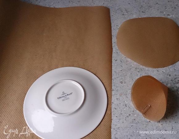 Из бумаги для запекания вырезать 10 кругов по 16 см в диаметре. Разрезать до середины и свернуть в кулек. Закрепить канцелярской скрепкой. Поставить кончиком вниз в маленькие чашечки или форму для маффинов.