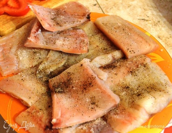 Размороженную рыбу нарезать порционными кусочками, посолить, поперчить