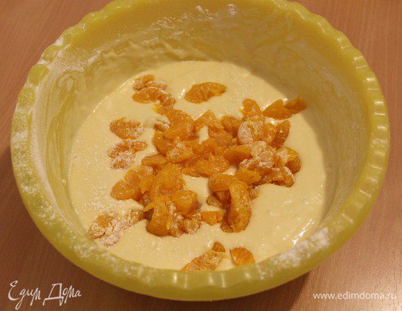 Мандарины слегка обваляйте в муке, добавьте в тесто и аккуратно перемешайте.