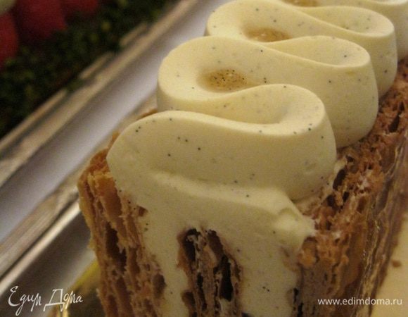 Сделать формат Мильфея, т.е. прямоугольник 20х30, поставить его на длинный бок, а верхний бок украсить из кондитерского мешка волнами. В этом случае при нарезке ничего у вас не расползется, не будет выдаваться по бокам. Это придумал мой кумир Кристоф, когда услышал от Поля Бокюза, что Мильфей невозможно есть элегантно. При нарезке десертными ножами и вилками, слоеные коржи всё равно поползут, укусить тоже красиво не получается... 

Тогда Кристоф Мишалак придумал ставить торт на бок, украшать эстетично верхний бок и нарезать порции, перпендикулярно изначальной сборке :-) 

Торт в разрезе на фото.