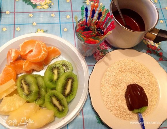 Растопили шоколад на водяной бане, фрукты порезали как на фото, накололи кусочек фрукта и обмазали шоколадом, потом в кунжут и на тарелочку отдыхать. 