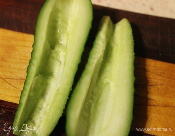 Морепродукты сложить в дуршлаг и дать маслу стечь. Яйца, крабовые палочки и огурец нарезать кубиками, предварительно удалив у огурца семечки.