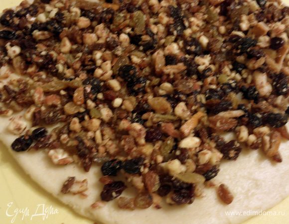 А теперь отличный способ вмешивать изюм и орехи в тесто. Делим тесто на 3-4 куска. Каждый кусок разминаем в пласт и покрываем слоем добавок. Хорошо их вдавливаем руками.