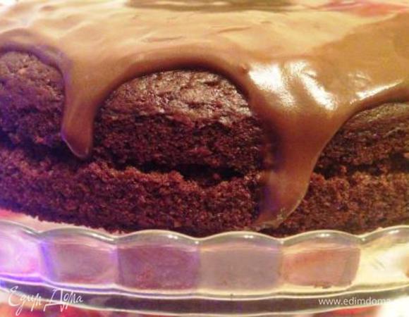 Остывший пирог вынуть из формы, разрезать вдоль пополам, смазать половиной крема, накрыть вторым коржом и залить остатками крема.