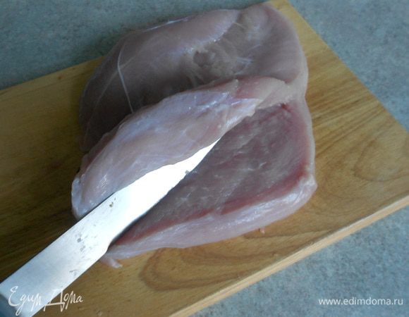 Каждое из 2 филе разложить на разделочной доске. Сначала нужно отвернуть  в сторону (но не отрезать) малое филе, затем разрезать горизонтально толстую часть большого филе, т.е. до середины примерно. 
