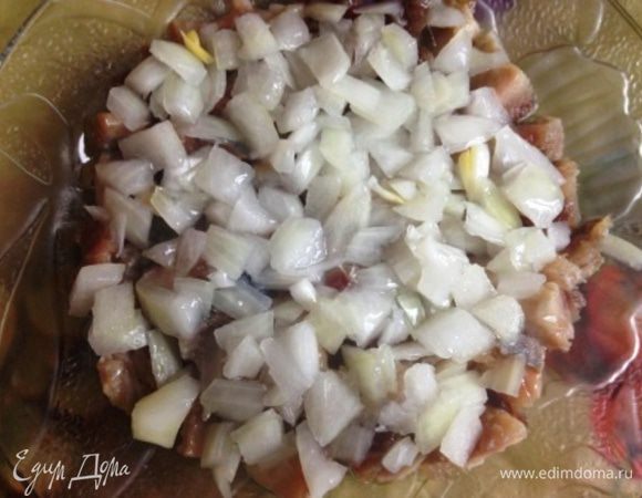 На дно тарелки плотно уложить кубики селедки, на нее - кубики лука (я его предварительно мариную в лимонном соке - но это по желанию). Полить растительным маслом.