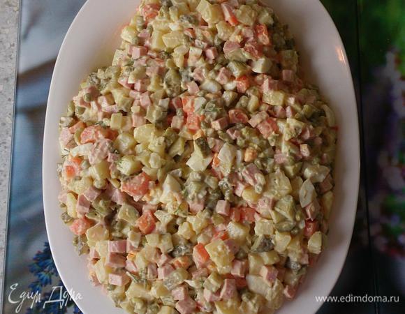Готовим салат как обычно. Отвариваем картофель, морковь, яйца, даем остыть. Тем временем нарезаем кубиками колбасу, огурцы; затем картофель, морковь, яйца. Я добавляю немного огуречного рассола. Солим, перчим по вкусу. Добавляем рубленый укроп, зеленый горошек. Заправляем майонезом. Выкладываем на сервировочную тарелку в форме овала, сверху немного уже.