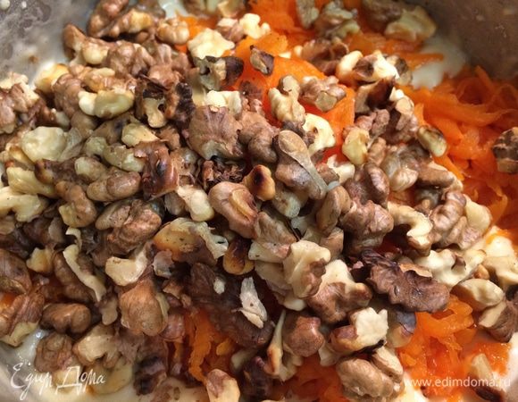 Орехи поджарить на сухой сковороде, остудить, порубить средними кусочками.
Сырую тыкву натереть на крупной терке. 
Яйца взбить с сахаром до образования пышной массы. Добавить просеянную муку и соду, погашенную уксусом. Затем ввести тыкву и орехи, аккуратно перемешать получившееся тесто.