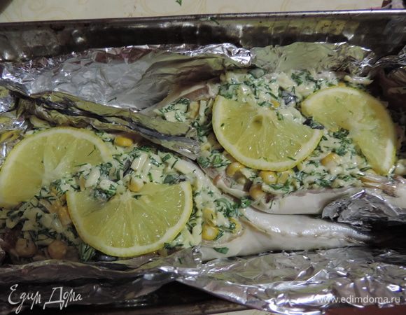 Полученной начинкой фаршируем рыбку, сверху на начинку выкладываем половинки кусочков лимона. Форму для запекания выстилаем фольгой и выкладываем скумбрию брюшком вверх. Форму желательно взять узкую и глубокую, чтоб она поддерживала рыбку и не давала упасть.