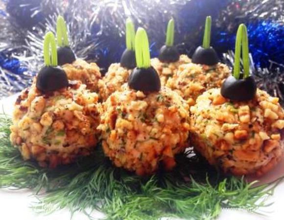 Из полученной массы скатать шарики, обвалять из в ореховой крошке.
Из половиной оливок сделать "крепления", из зелени "петельки", положить на тарелку, украсить зеленью и подать на стол!