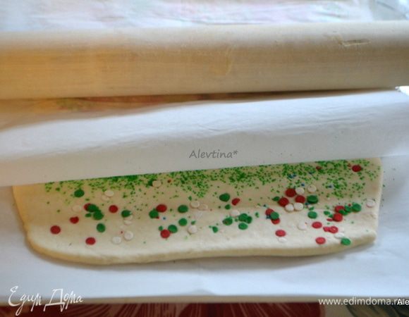 Сверху присыпаем поверхность теста крупным сахаром и сладкой цветной крошкой. Затем вновь накроем бумагой для выпечки и слегка пройдемся скалкой, чтобы украшение лучше впечаталось в тесто. 
Или смешиваем какао порошок с крупным сахаром и также выкладываем на раскатанное тесто.