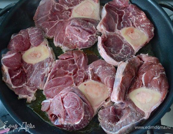 Подготовленное мясо для оссобуко лучше заранее достать из холодильника... Посолить и сразу же обжарить в большой глубокой (!) тяжелой сковороде на оливковом масле.