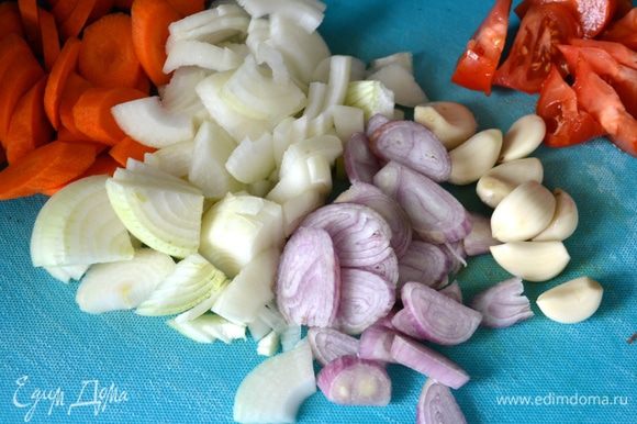 Овощи (морковь, репчатый лук, лук-шалот, помидор) вымыть и нарезать средними кусками. Очистить чеснок и подготовить ароматические травки.