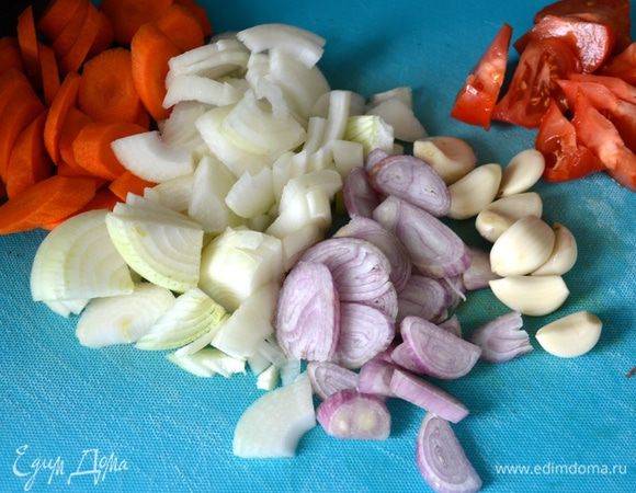 Овощи (морковь, репчатый лук, лук-шалот, помидор) вымыть и нарезать средними кусками. Очистить чеснок и подготовить ароматические травки. 