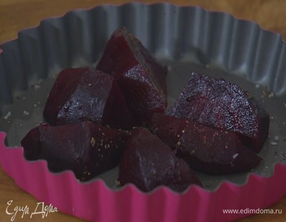 Дно двух небольших форм для выпечки посыпать солью, свежемолотым перцем и выложить дольки свеклы.