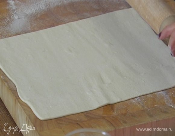 Рабочую поверхность присыпать мукой, немного раскатать тесто и вырезать круги диаметром чуть больше формочек.