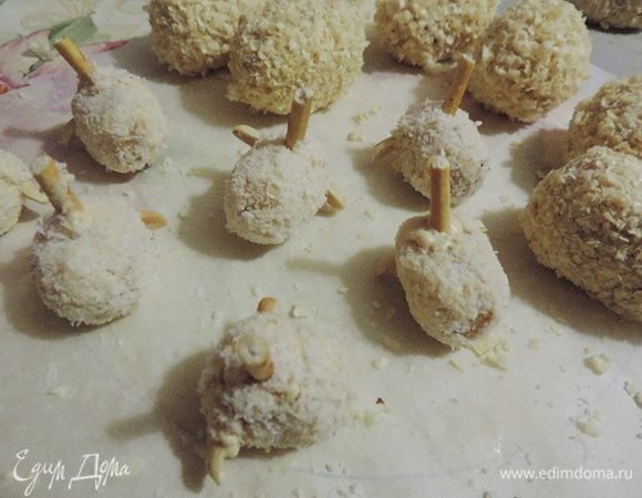 Теперь к "головам" приклеиваем белым шоколадом половинки очищенного арахиса - ушки. И очень осторожно вставляем кусочки соломки - с их помощью мы будем крепить голову к туловищу.
Если заготовки будут растрескиваться - не расстраиваемся, все трещинки маскируем белым шоколадом (остатки шоколада перекладываем в кондитерский мешочек со срезанным уголком) и присыпаем кокосовой стружкой. Прежде чем вставить соломку, лучше аккуратно проткнуть отверстие чем-то острым, я использовала деревянную ручку от кисточки для рисования.