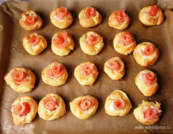 Кусочки семги свернуть в трубочку и вложить в профитроли.