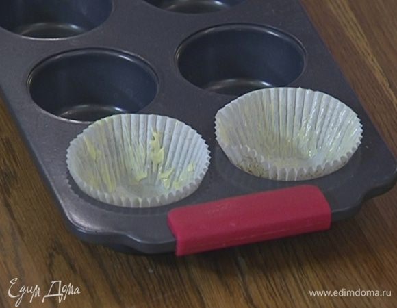 Бумажные вкладыши для кексов смазать оставшимся сливочным маслом и вложить их в формочки.