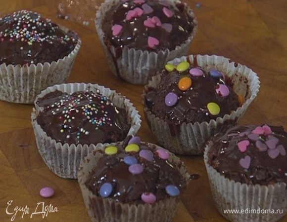 Готовые капкейки полить шоколадной глазурью и украсить сахарными бусинками и сердечками.