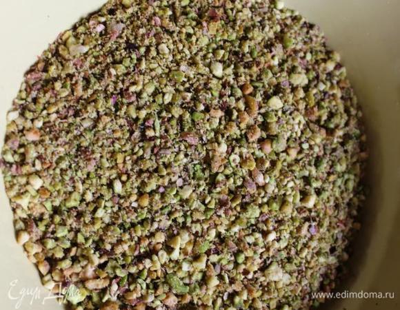 Фисташки нам нужны несоленые и измельченные. Если таких нет в продаже (как в моем случае), то заранее их подготовим. Приблизительно грамм 150 (можно немного меньше, так как у меня орешки еще остались) фисташек чистим от скорлупы и промываем в холодной воде. Подсушиваем на бумажном полотенце, а затем на горячей сковороде без масла. Если есть время и желание, то можно избавить орехи и от шелухи, я оставила как есть. 
Измельчаем орехи при помощи кухонной техники.