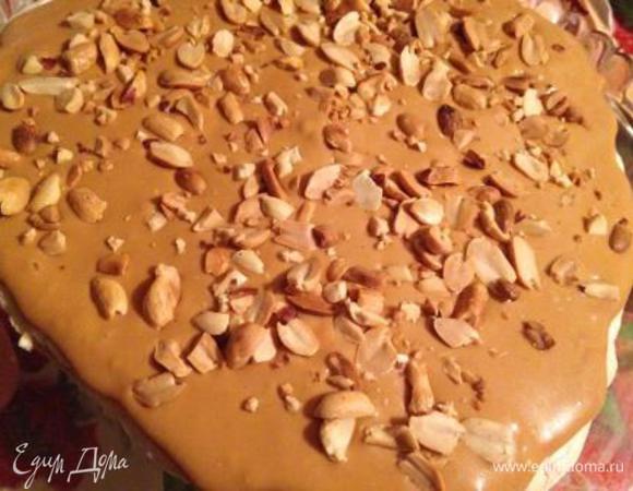 На блюдо положить 1 корж (безе вверх).
На него намазать половину крема и высыпать половину жаренного арахиса.