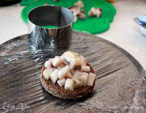 Горкой положите на хлеб кусочки филе малосольной сельди.