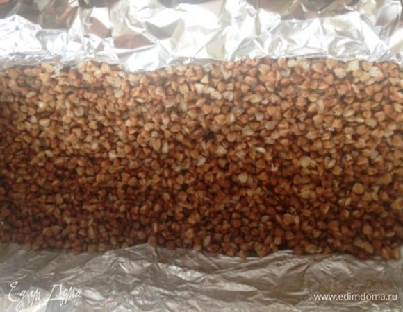 Глубокую форму застелить фольгой, смазать маслом и выложить половину гречки.
