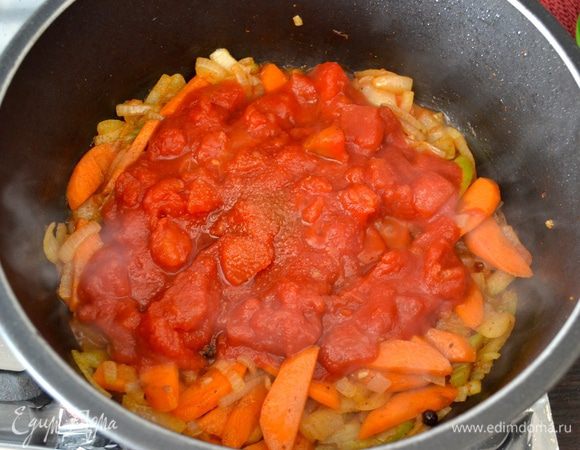 Добавить помидоры в собственном соку, размять, всыпать щепотку сахара. Перемешать и обжарить еще пару минут.