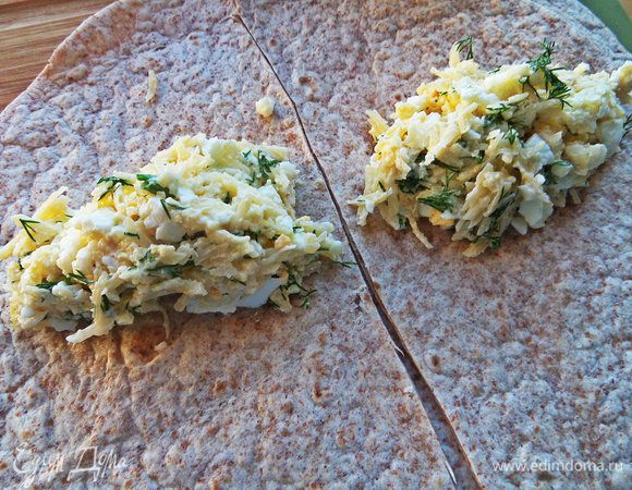 Тортилью разрезать пополам,на каждую часть положить ложку начинки.