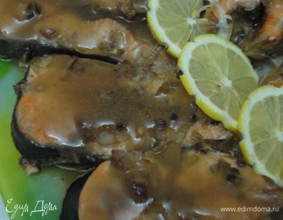 Часть маринада, примерно 1/2 стакана, слейте в отдельную посуду (желательно без овощей и пряностей), а оставшуюся часть (при необходимости) разбавьте ½ стакана воды. Рыбное филе залейте разведенным маринадом и тушите 20-25 минут в нагретой до 200-220 градусов духовке. 

Оставшийся маринад доведите до кипения, добавьте разведенный небольшим количеством воды крахмал и проварите до загустения.

Перед подачей уложите филе на подогретую тарелку, полейте соусом и оформите лимоном и зеленью.
