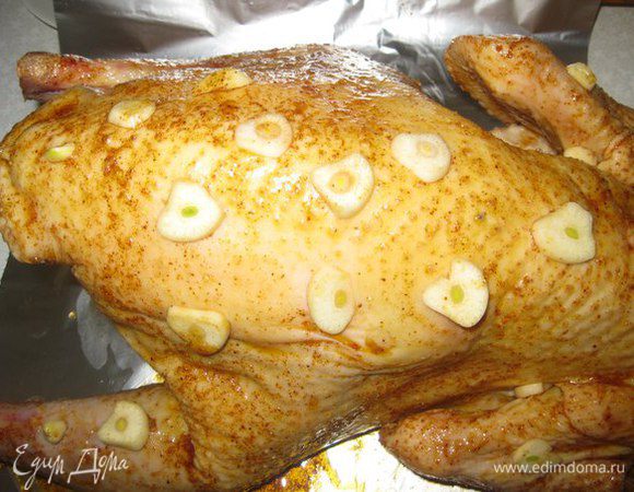 Всю Индейку обмазываем смесью по бокам и внутри. Обкладываем чесноком. Она получается такая красивая, уже даже румяная.