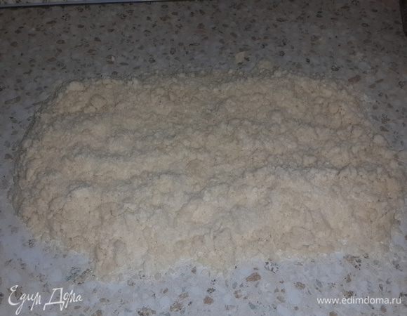 Маргарин растираем с мукой на столе. Кладём в серединку сметану и на неё пол-ложки соды. Добавляем все остальные ингредиенты. Всё делаем быстро "шмяк-бряк" и готово. Получаются такие крошки. Оставляем на столе наше сыпучее тесто и начинаем делать начинку.