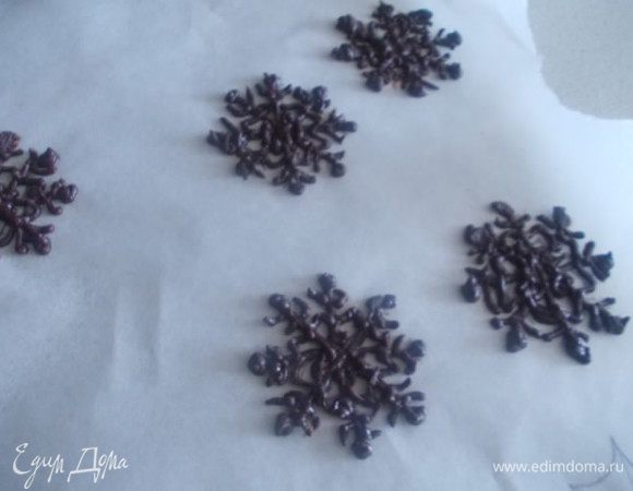 Растапливаем шоколад с маслом. На пергаменте нарисовать снежинки карандашом, а потом с помощью кондитерского конверта, нарисовать снежинки. Дать застыть.