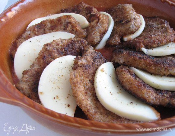 На томатную массу выложить отбивные внахлест, перемежая их пластиками моцареллы.