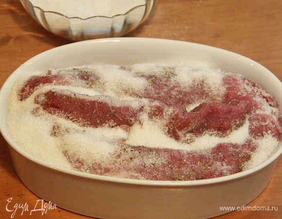 Мясо уложить на "солёную подушку", со всех сторон обсыпать оставшейся смесью соли и сахара. 