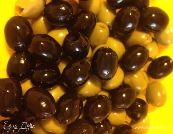 Подготовить контейнер с крышкой, в него выложить оливки зеленые и черные.