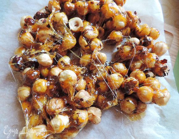 Для пралине нам понадобится карамель. Для ее  приготовления сахар надо растопить в сотейнике или кастрюльке с толстым дном. Делать это нужно на среднем огне. У моей плиты 12 уровней нагрева, я делаю это на 7. Расплавленный сахар держим до приобретения им янтарного цвета. 

Всыпаем обжаренный очищенный фундук в карамель, все перемешиваем и выливаем содержимое на пергамент. Равномерно распределяем массу и даем остыть.