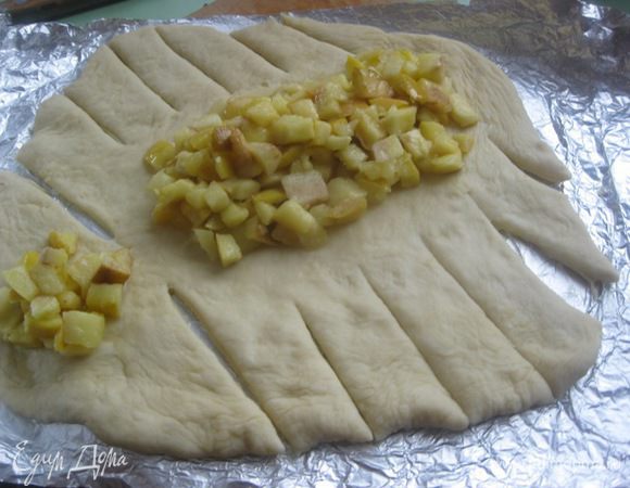 Развернуть тесто и надрезать на равные полосы.
Выложить начинку.