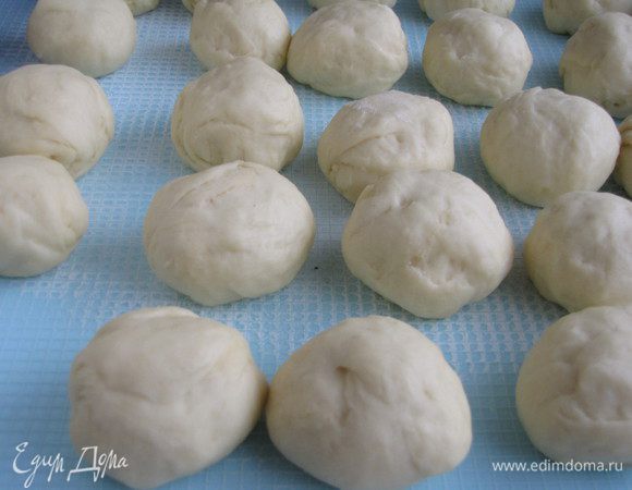 Подошедшее тесто обмять и, отрезая небольшие кусочки, формировать шарики. Булочки у нас будут не большими, поэтому стараемся сделать примерно 24 шарика. Прикроем их полотенцем, дадим немного подойти и начинаем формировать булочки.