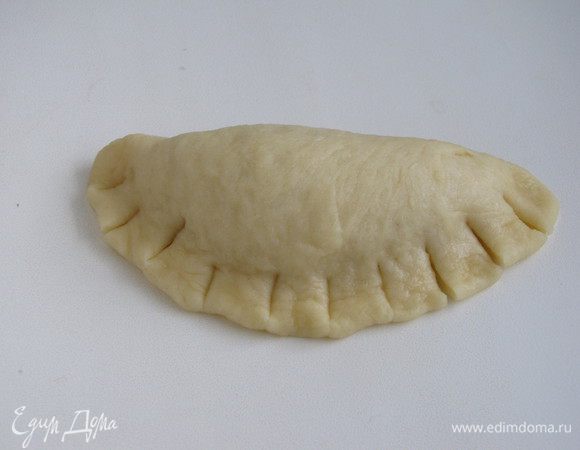 Сложить лепешку пополам и хорошо прижать края, сделать ножом надрезы.