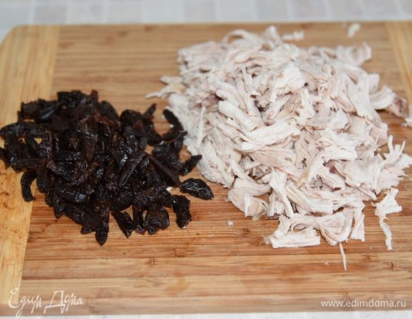 Чернослив залить кипятком на 10 минут, обсушить полотенцем и нарезать соломкой. Курицу разобрать на недлинные волокна.