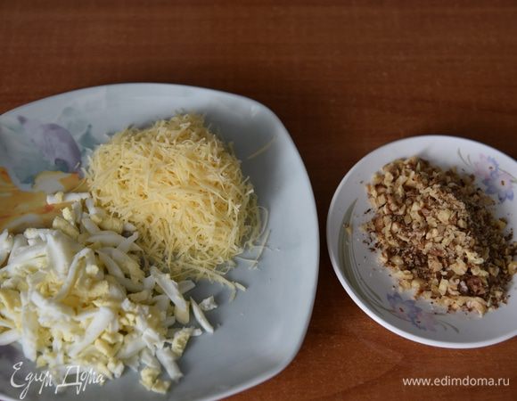 Яйца натереть на крупной терке, сыр — на мелкой. Орехи порубить ножом не очень мелко.