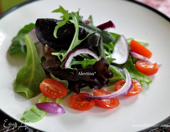 Разложим по тарелкам салатную смесь. Затем красный лук порезанный, помидоры шерри порезанные пополам.