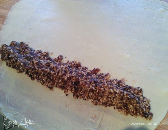 Теперь тесто следует раскатать очень тонко, примерно 1 мм толщиной, выложить начинку ( можете орехи не использовать вообще) и завернуть плотным рулетом. 