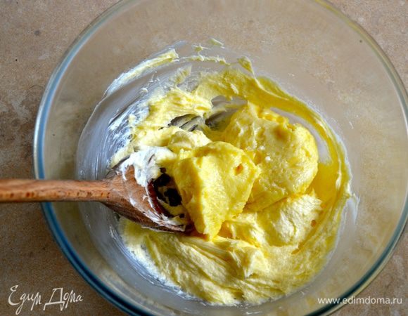 В отдельной миске слегка взбить с помощью деревянной ложки размягченное сливочное масло и добавить в него по частям полностью остывший заварной крем. Размешать.